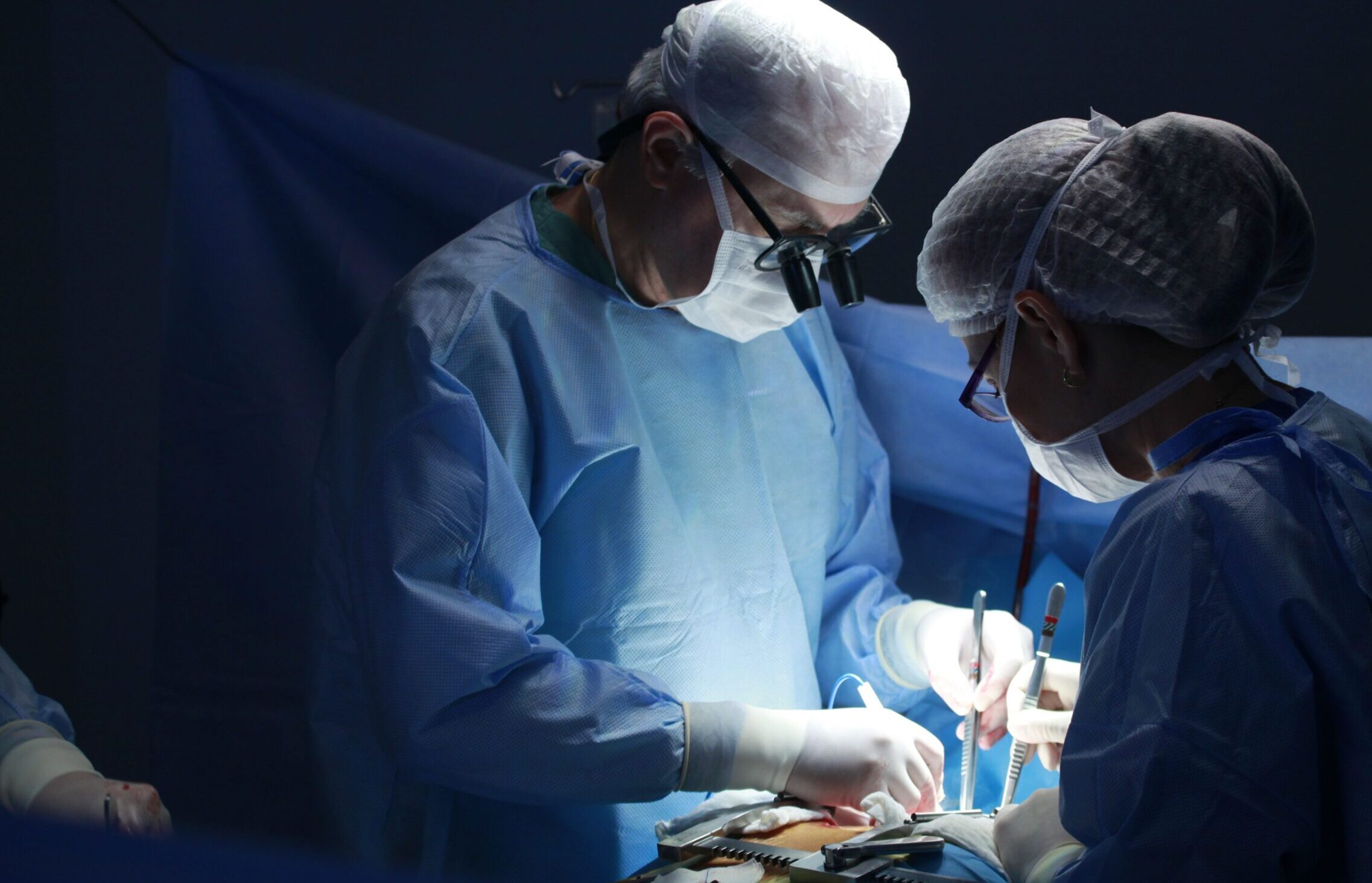 Two medical professionals performing surgery